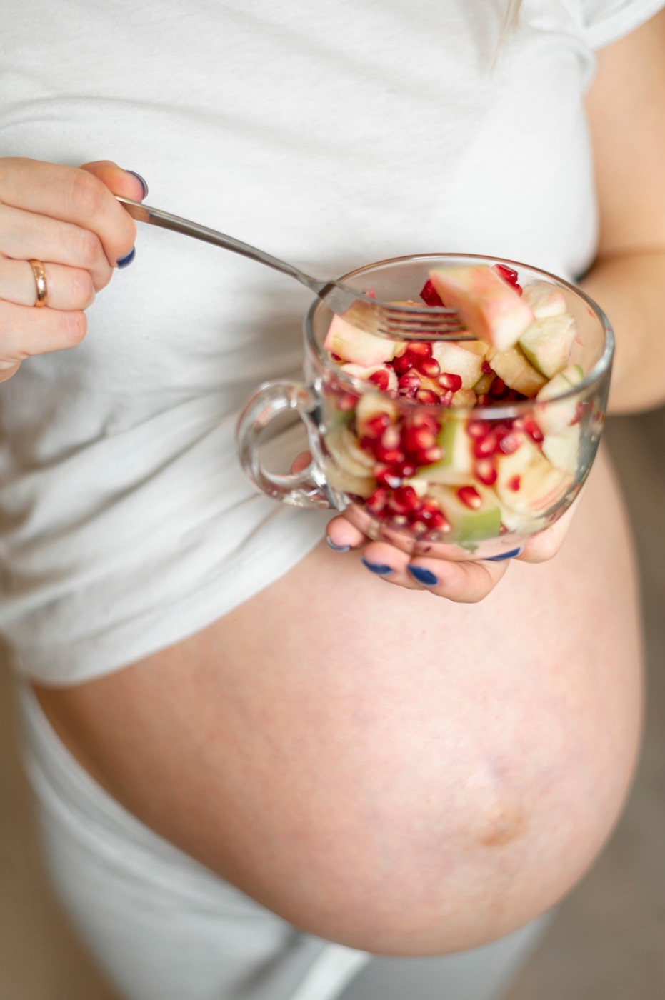 A woman eating a cup of fresh fruit